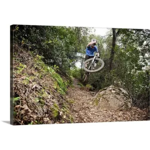 "A young man rides his downhill mountain bike on Knapps Castle Trail" Canvas Wall Art